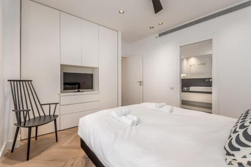 um quarto branco com uma cama e uma cadeira em Stunning and design 2BDR Apartment em Tel Aviv