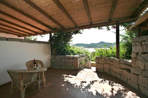 a patio with a table and chairs under a wooden pergola at Hotel Palumbalza Porto Rotondo in Porto Rotondo