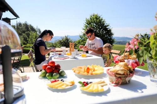 un grupo de personas sentadas en una mesa con comida en Hunting Tower Na Škaluc, en Šentrupert