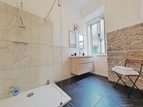 a bathroom with a shower and a tub and a sink at Casa Bianca - 2 Bedroom Design Apartment in Trieste