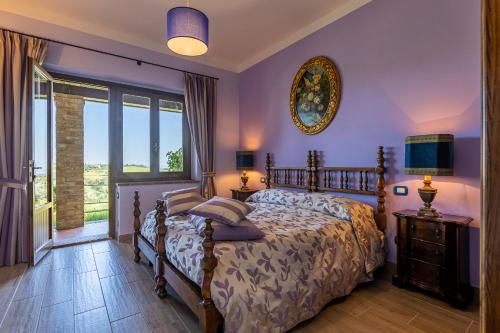 ein Schlafzimmer mit einem Bett mit lila Wänden und einem Fenster in der Unterkunft B&B FONTERONCONE di KRYVUTA OKSANA in Montepulciano