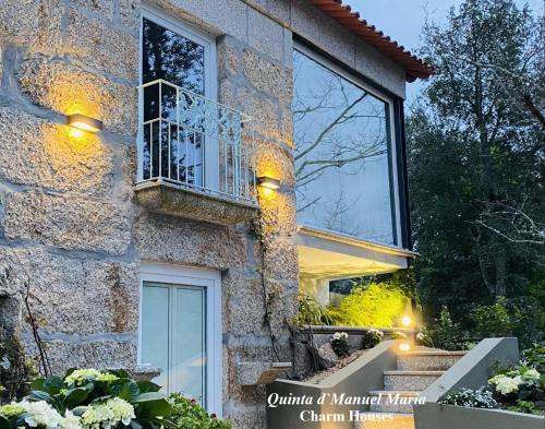Cette maison en pierre dispose d'une fenêtre et d'un balcon. dans l'établissement Quinta D`Manuel Maria- Rural Charm Houses, à Amarante