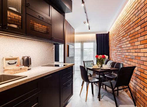 a kitchen with a brick wall and a table with chairs at Apartamenty Gdansk EU - Dwie Motławy - OLD TOWN in Gdańsk