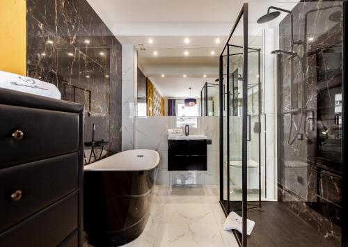 y baño con ducha acristalada y lavamanos. en Apartamenty Gdansk EU - Apartament Panorama en Gdansk