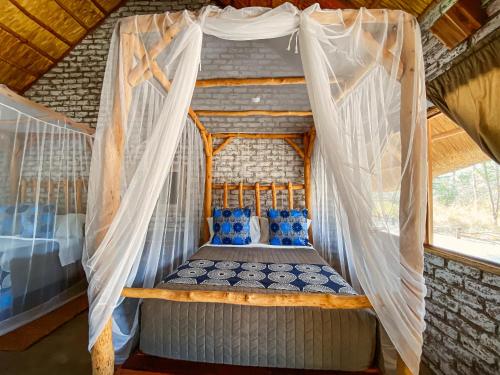 Gwango Heritage Resort في Dete: سرير في خيمة مع ناموسيات