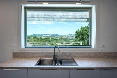 a kitchen sink and a window with a view at Villa Tramonto - Camerano, meravigliosa villa con giardino panoramico in Camerano