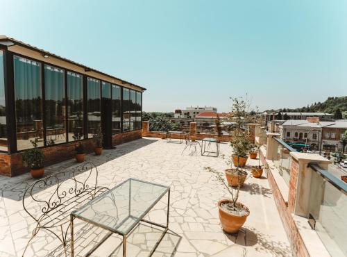 a patio with chairs and tables on a roof at Boutique Hotel Verdzi in Kutaisi