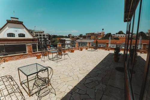 a patio with chairs and tables on a building at Hotel Verdzi in Kutaisi