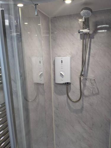 a bathroom with a shower stall with a hair dryer at Orchard House in Peterborough