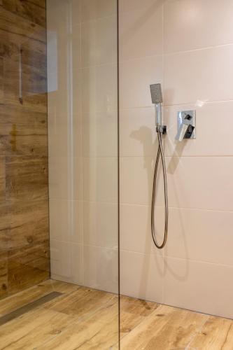 a shower with a shower head in a bathroom at Kalinowe Wzgórza in Charzykowy