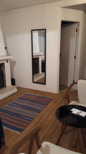 a living room with a mirror and a table at Bongusto Apart House Locações Mantiqueira in Monte Verde