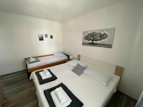a room with two beds and a tree on the wall at Apartmani Juricev Vodice in Vodice