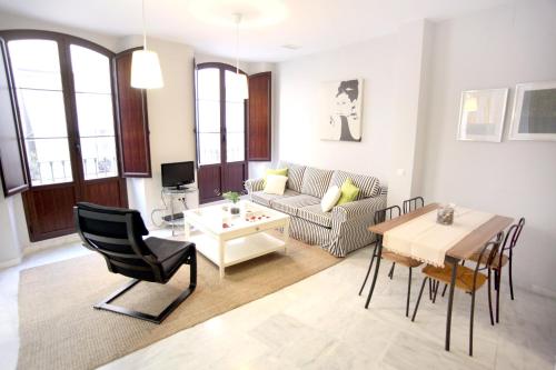 uma sala de estar com uma mesa e um sofá em Sleepin Sevilla em Sevilha