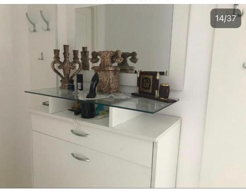 a white dresser with a glass counter top on it at Belle Maison in Hammamet