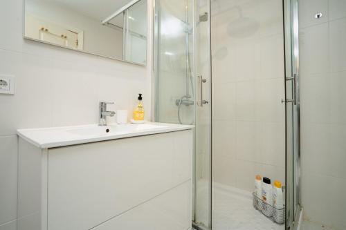 ein weißes Bad mit einem Waschbecken und einer Dusche in der Unterkunft Romana playa 724 in Marbella