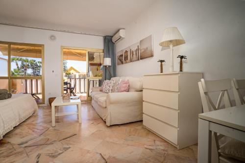 uma sala de estar com um sofá e uma mesa em Romana playa 724 em Marbella