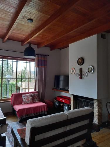 a living room with a couch and a fireplace at Bongusto Apart House Locações Mantiqueira in Monte Verde