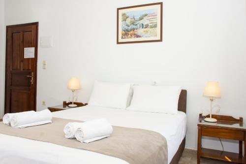 two beds in a white room with towels on them at Argo Rooms-Papadakis in Kissamos