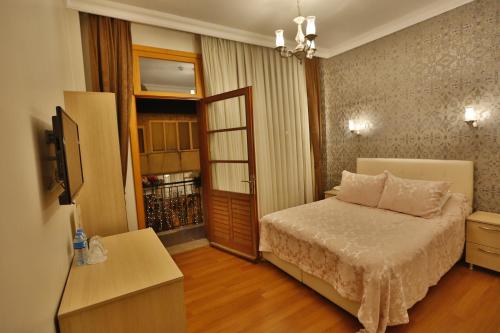 - une chambre avec un lit et une porte donnant sur un balcon dans l'établissement Mimoza Butik Otel Buyukada, à Büyükada