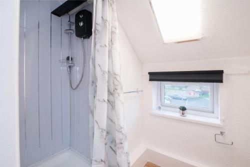 a bathroom with a shower curtain and a window at DD Apartment 10 - Free Parking - Fast WiFi in Castle Donington