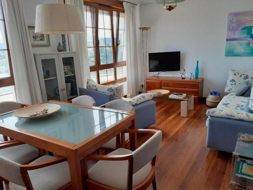 a living room with a glass table and chairs at La Casa de la Bahía in San Vicente de la Barquera