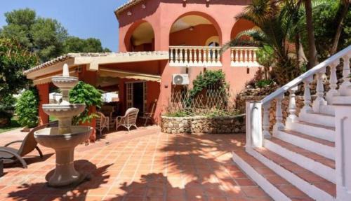 una casa con una escalera que conduce a un patio en Beautiful modern 4 bedroom villa with heated pool and cinema in Las Lagunas de Mijas, en Santa Fe de los Boliches