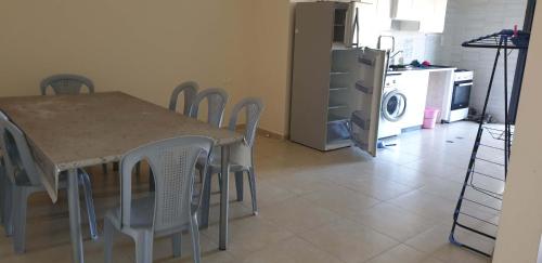 d'une salle à manger avec une table, des chaises et un réfrigérateur. dans l'établissement Big Appatrment in Hebron Palestine Almahawer, à Hébron