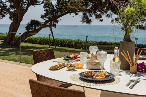 einen Tisch mit Essen und Meerblick in der Unterkunft ME Ibiza - The Leading Hotels of the World in Santa Eulària des Riu