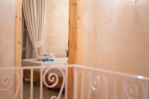 a small room with a bed and a mirror at Ta' Ganna Farmhouse in Sannat