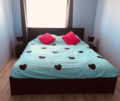 un letto con cuscini rosa e un piumone blu di TESTO Apartments a Mielno