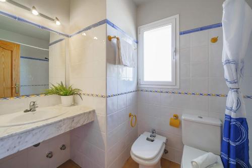 bagno con lavandino, servizi igienici e finestra di Villa Trufa by Villa Plus a Jávea