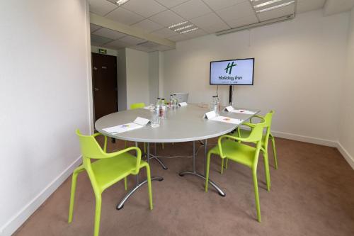 a conference room with a white table and green chairs at Holiday Inn Lyon Vaise by IHG in Tassin-la-Demi-Lune