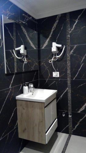 a bathroom with a sink and a black wall at Bungalovi Ključ in Ključ