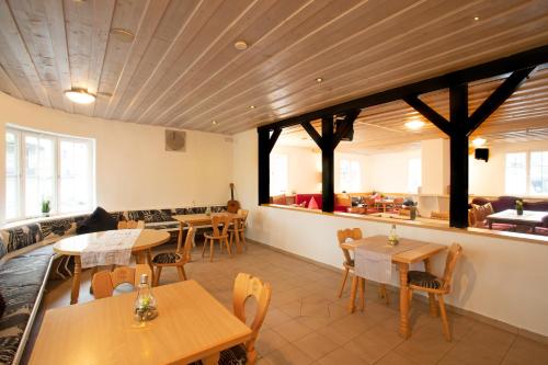 un restaurant avec des tables et des chaises en bois et une cafétéria dans l'établissement Hostel Westküste, à Lindau