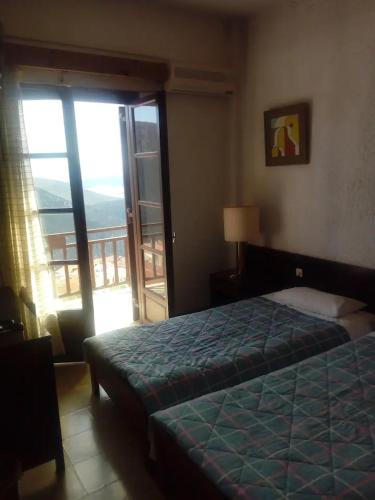 a bedroom with a bed and a view of a balcony at Panoramic view 2 in Delphi