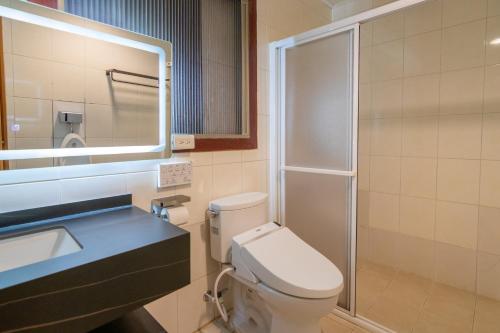 a bathroom with a toilet and a sink and a shower at Kinmenhouse Villa No 7 in Jincheng