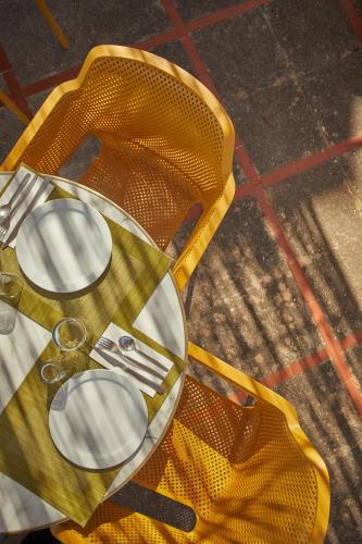 einem gelben Tisch mit Tellern und Besteck in der Unterkunft Agroturismo Alquería Blanca in Bunyola