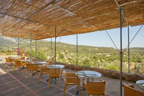 eine Terrasse mit Tischen und Stühlen und Aussicht in der Unterkunft Agroturismo Alquería Blanca in Bunyola
