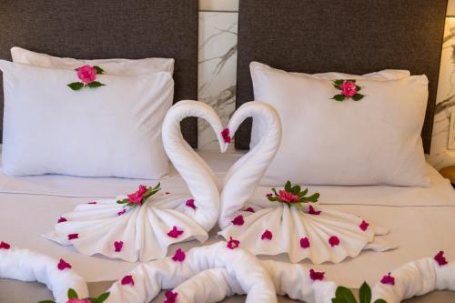 Dos cisnes haciendo un corazón en una cama en Orcey Hotel, en Datça