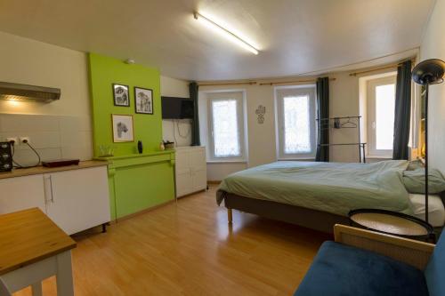 1 dormitorio con 1 cama y cocina con paredes verdes en Le First - proche Naval Group -, en Cherbourg-en-Cotentin