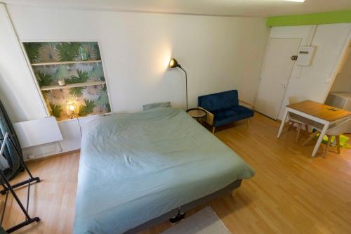 1 dormitorio con 1 cama, 1 mesa y 1 silla en Le First - proche Naval Group -, en Cherbourg-en-Cotentin