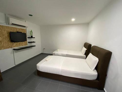 een hotelkamer met 2 bedden en een televisie bij LS VILLAGE HOTEL in Padang Besar