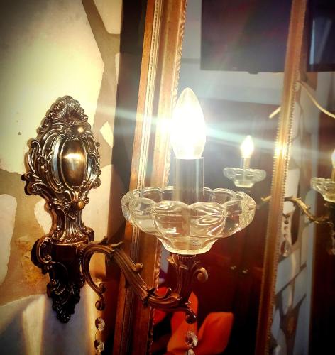 a lamp with a glass bowl next to a mirror at Pasas Castle - Unique Luxury Apartments in Naxos Chora
