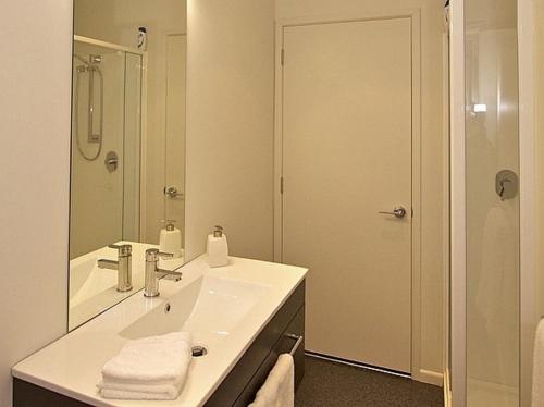 uma casa de banho branca com um lavatório e um espelho em Handbridge - Ohakune Holiday House em Ohakune
