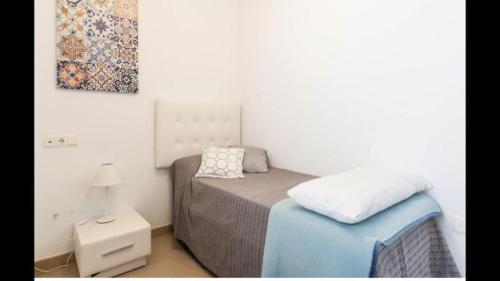 a small bedroom with a bed and a night stand at ático Tarifa in Tarifa