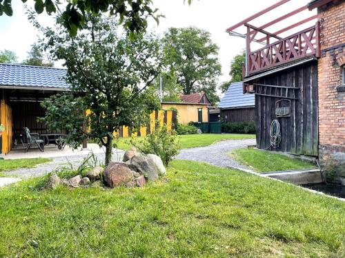 a garden with rocks in the grass next to a building at Lehdsche Heubuchten in Lehde