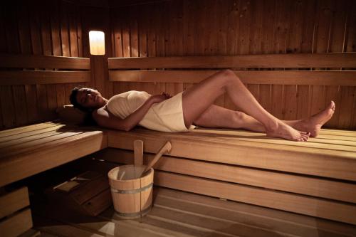 a woman is laying in a sauna at Apparthotel Samson in Obertauern