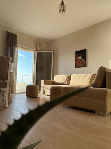 a living room with a couch and a large window at Lotus Apartments in Vlorë