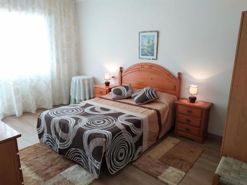um quarto com uma cama e duas mesas de cabeceira e uma janela em Apartamento Tranquilo Zona Paseo de Lordelo - WIFI em O Grove