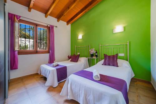 two beds in a room with green walls and windows at Villa Jaume by Villa Plus in Cumbre del Sol